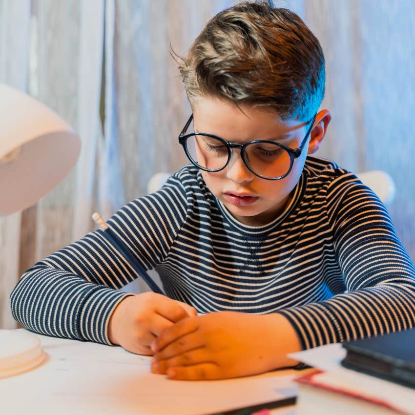 young boy doing homework alone without a parent's help