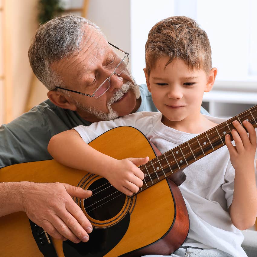 little kid with an active engaged grandparent learning guitar