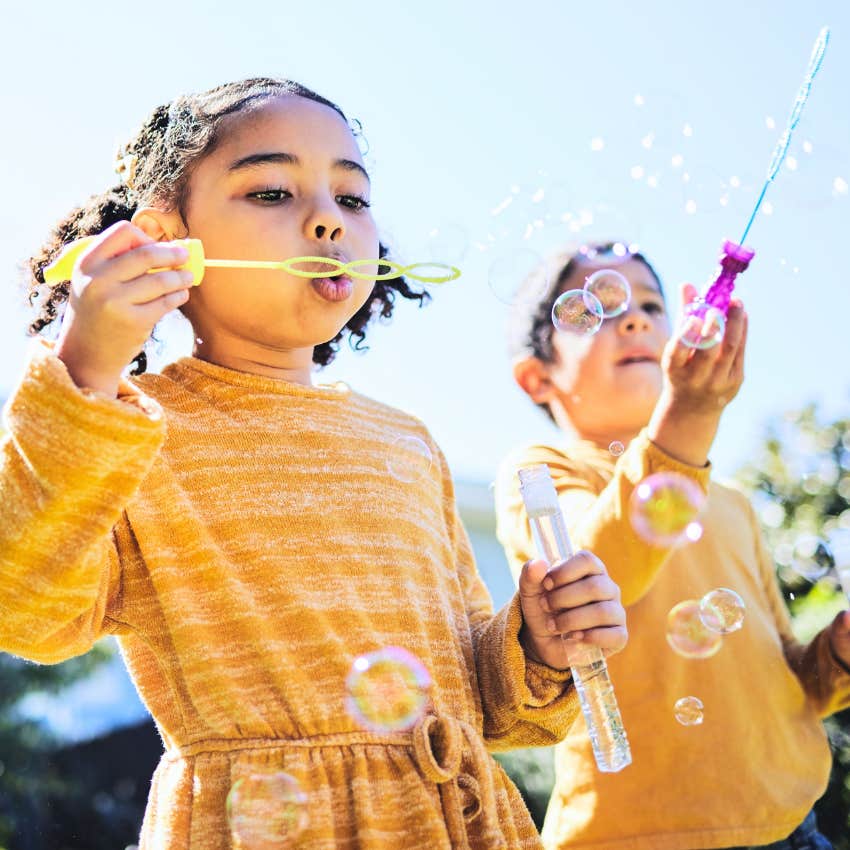 little kids using their free time to play outside and blow bubbles