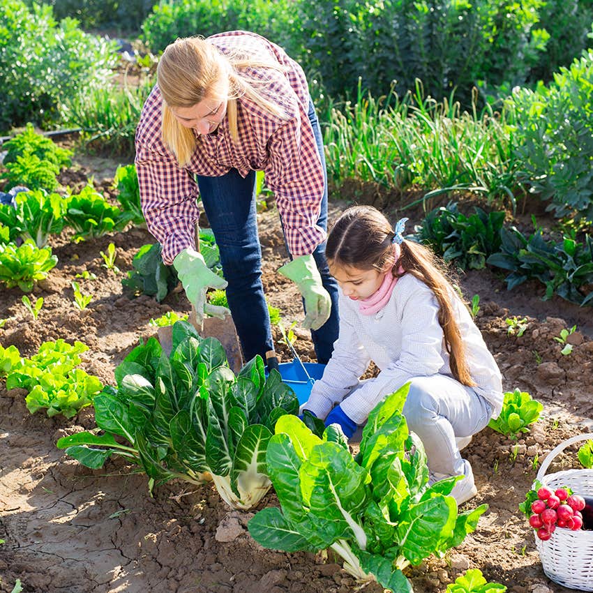 mother and daughter tending to vegetable garden being self-sufficient