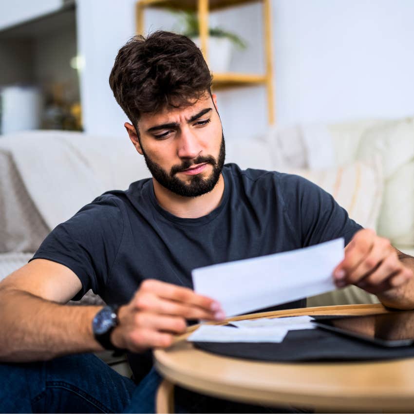 man looking at a check he received in the mail