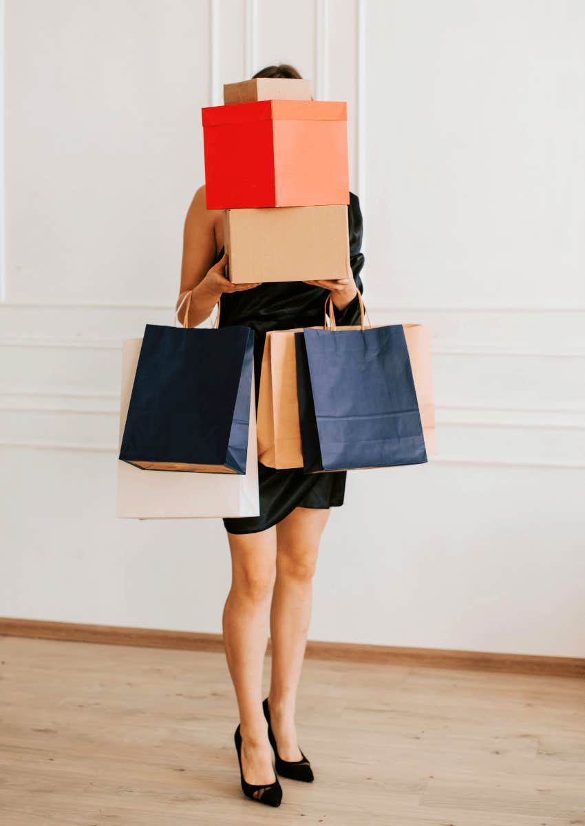 materialistic woman carrying several shopping bags and boxes