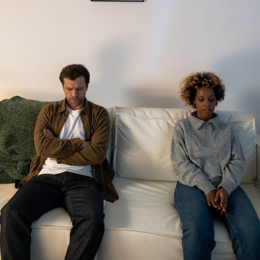 Couple sitting together on a bed with emotional distance despite earlier having a polite conversation