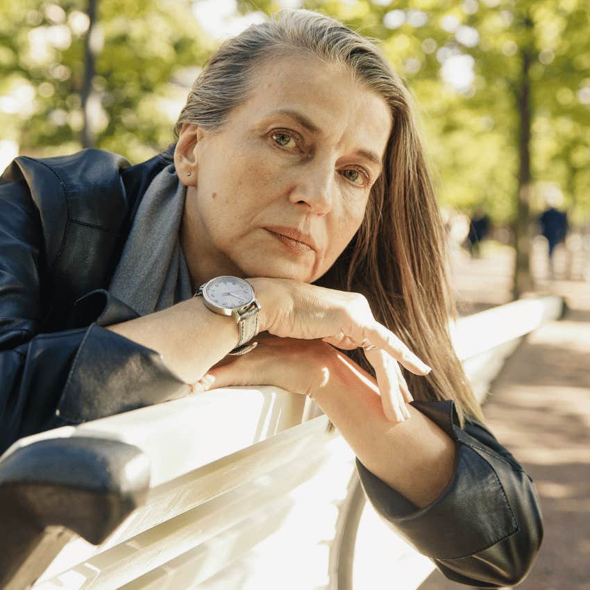 middle age woman sitting on park bench