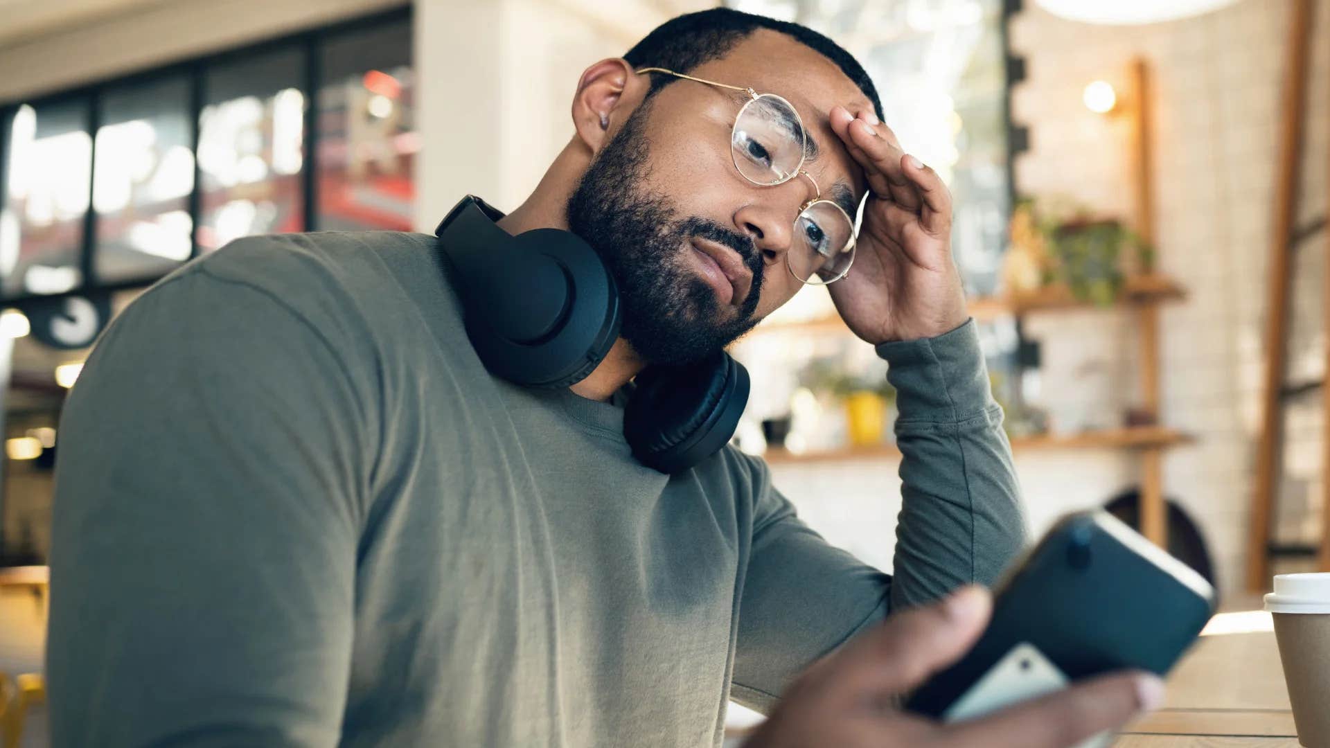 frustrated millennial man at work looking at his phone