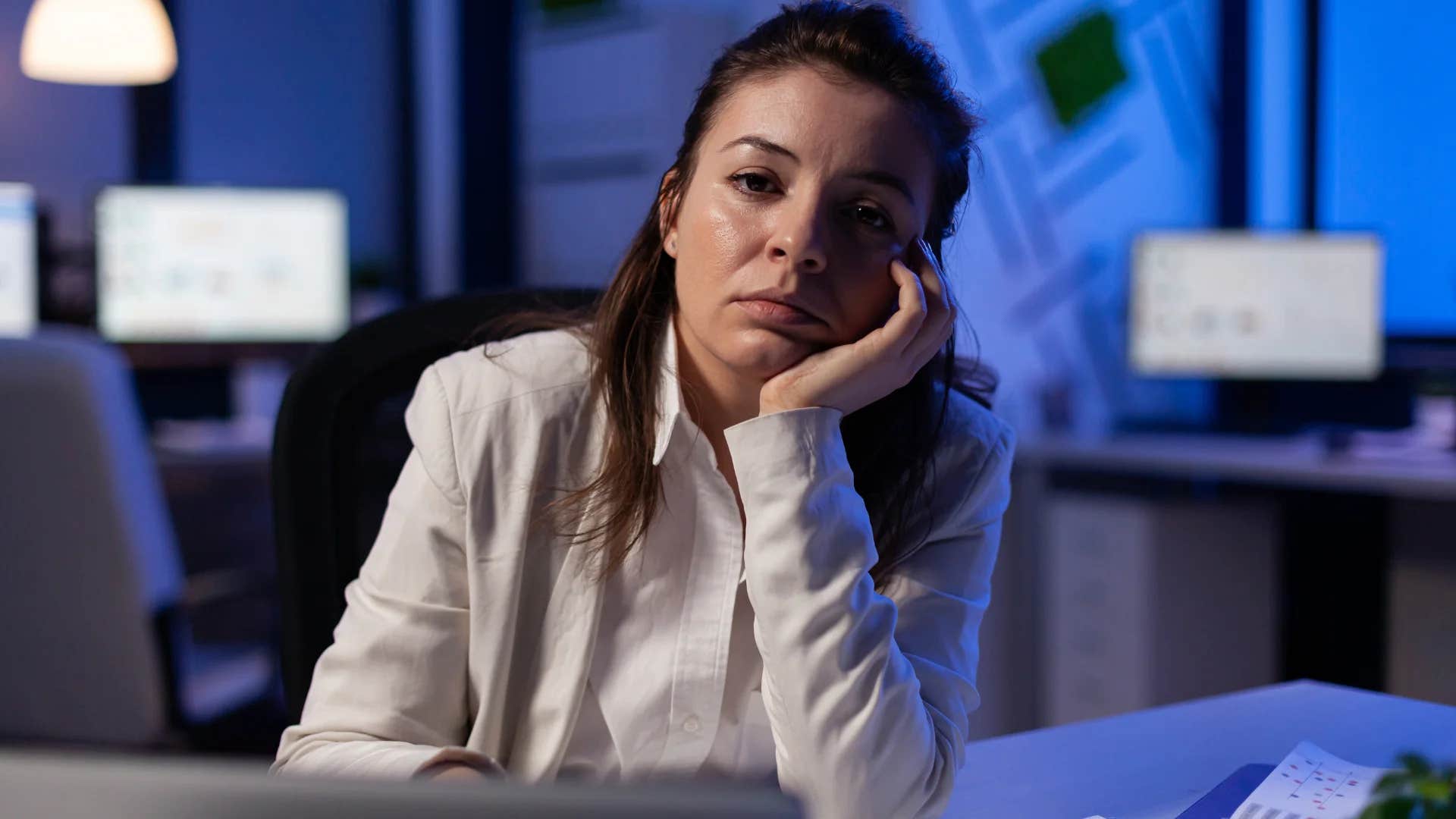 millennial woman daydreaming at work thinking about personal things
