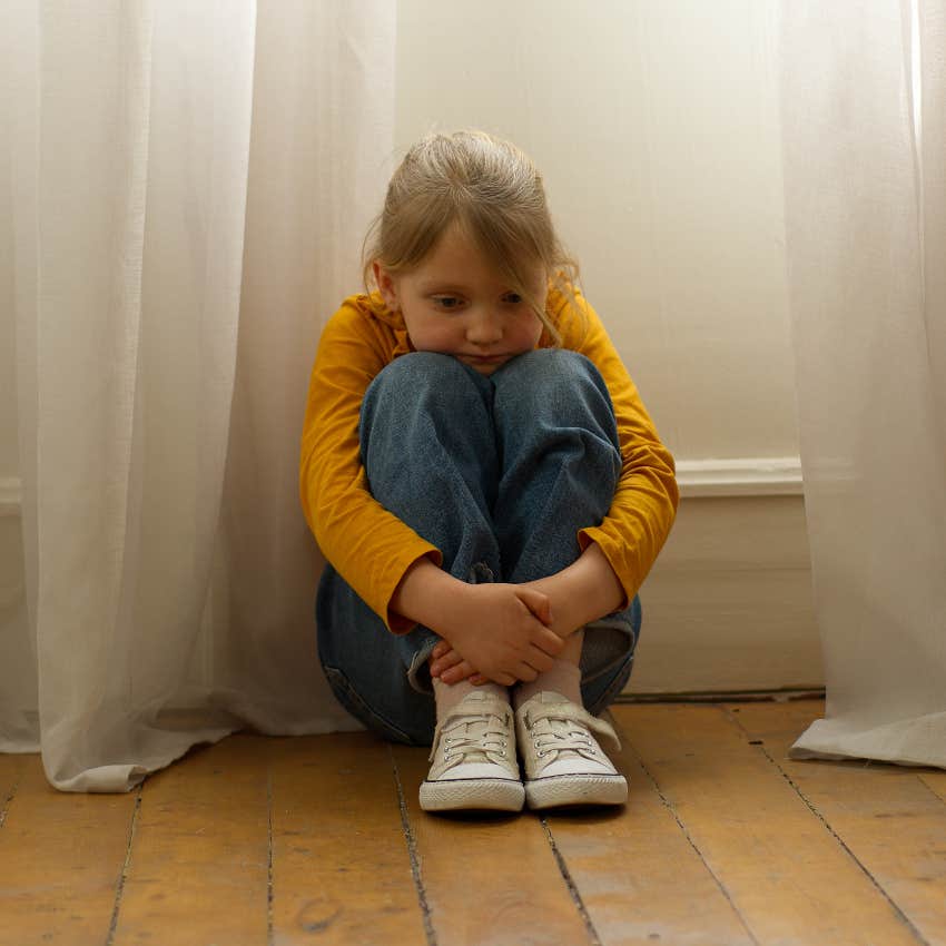 little girl hiding scared after parents fighting