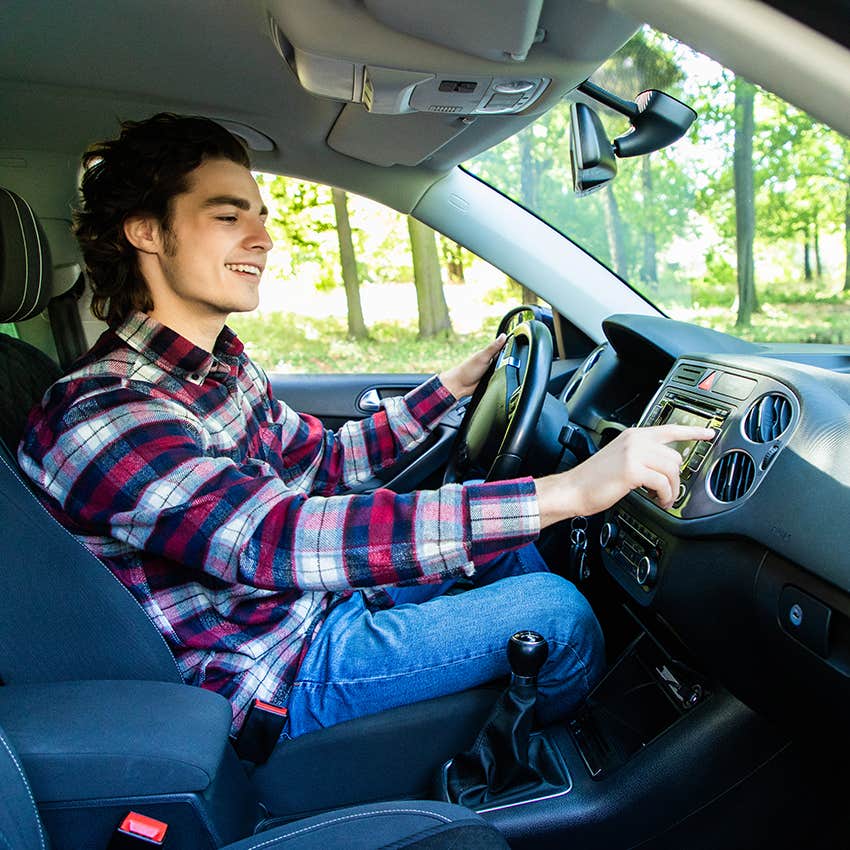 young man adjusting car radio to find station