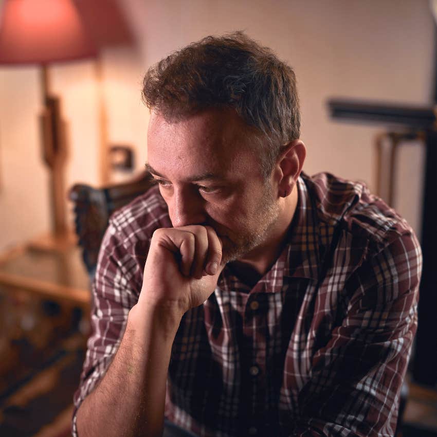 Man grieving something complicated at home alone.