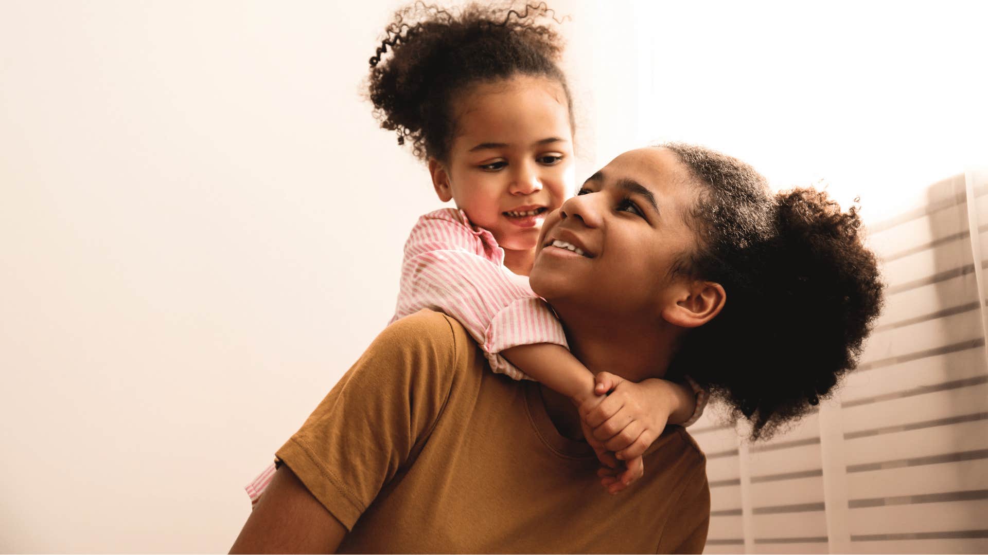 young girl babysitting her little sister at home