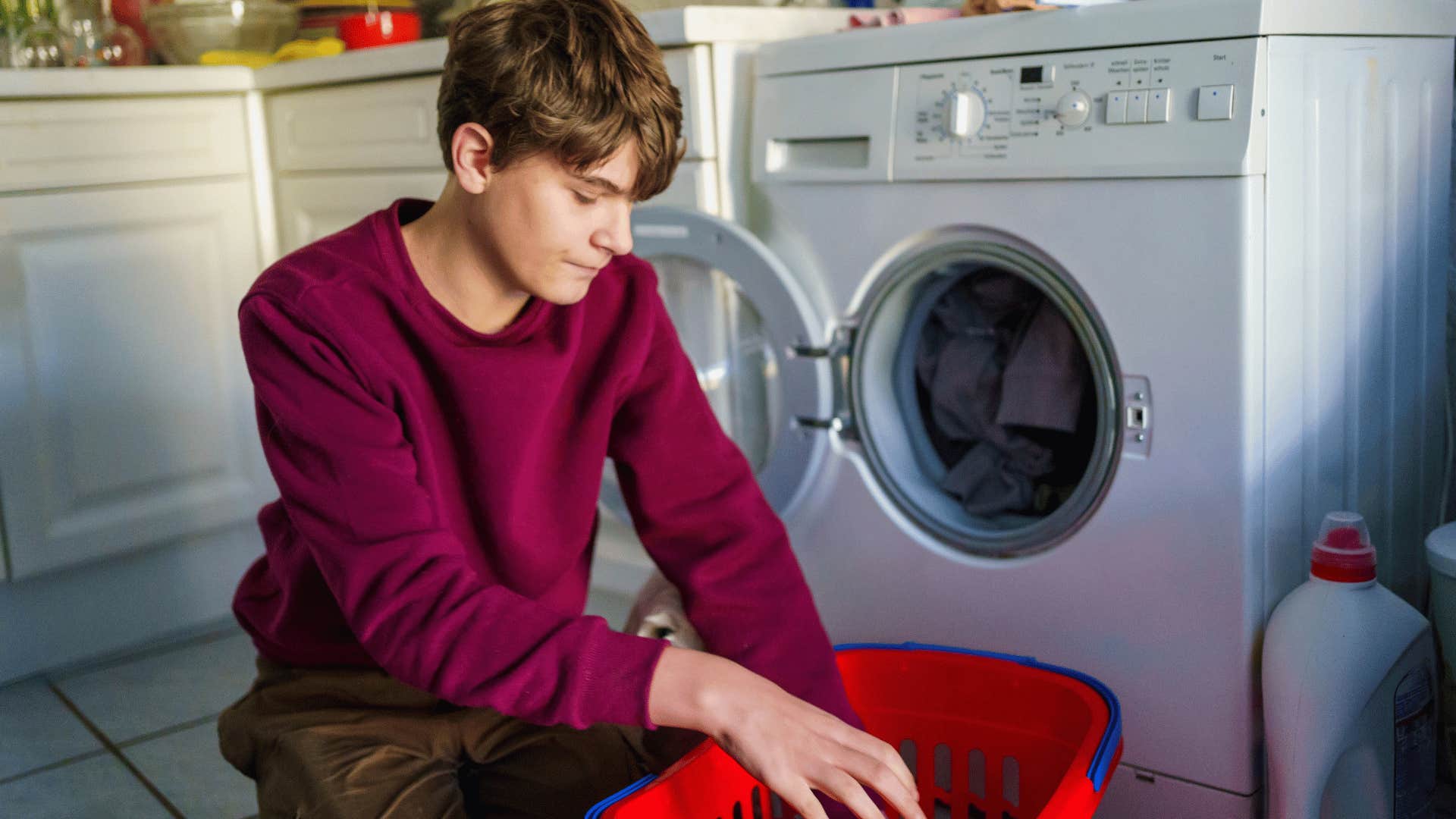 teenage boy washing and ironing clothes at home