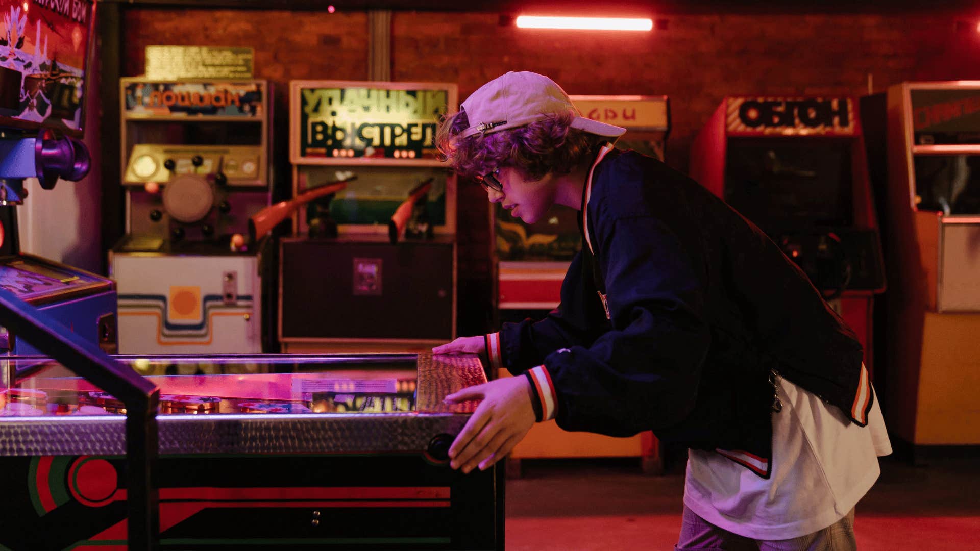 boy in white hat playing arcade games