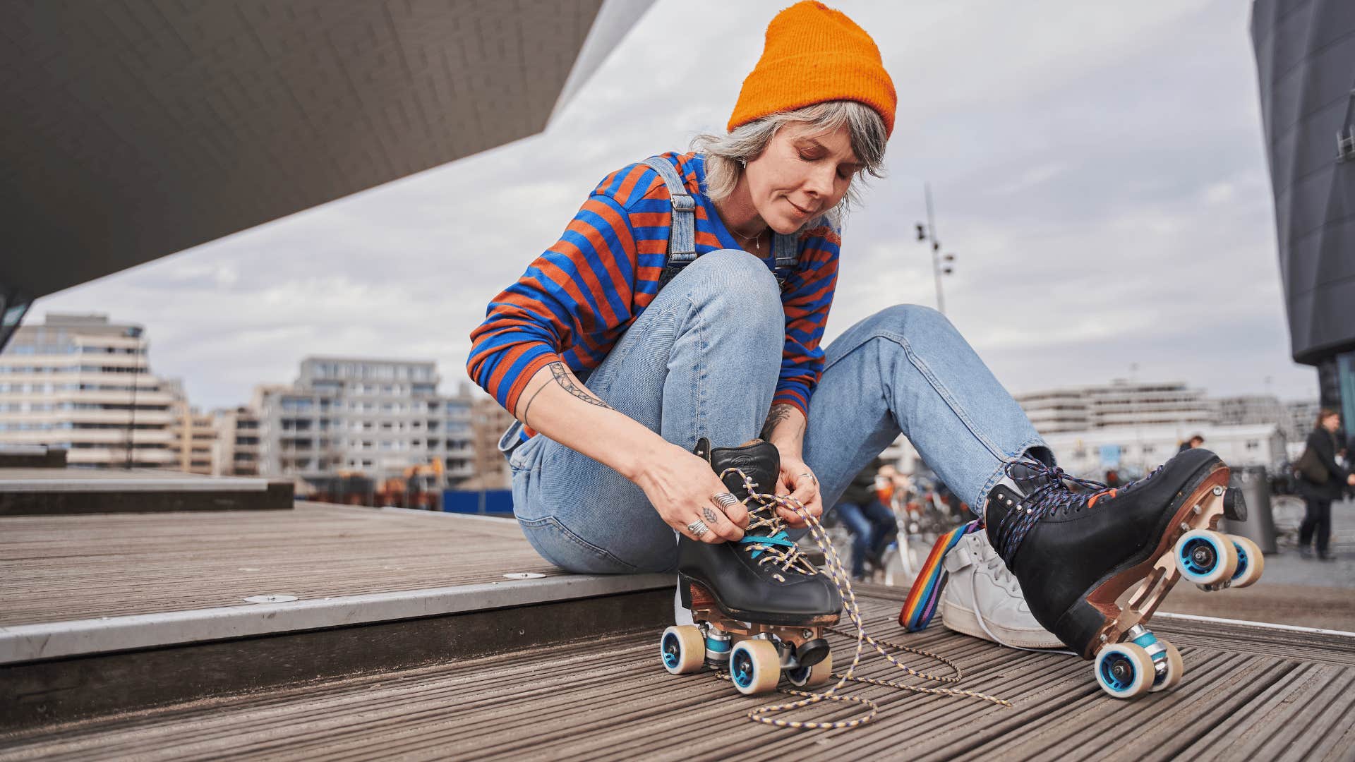 woman in orange hat putting on skates as she is about to rollerblade