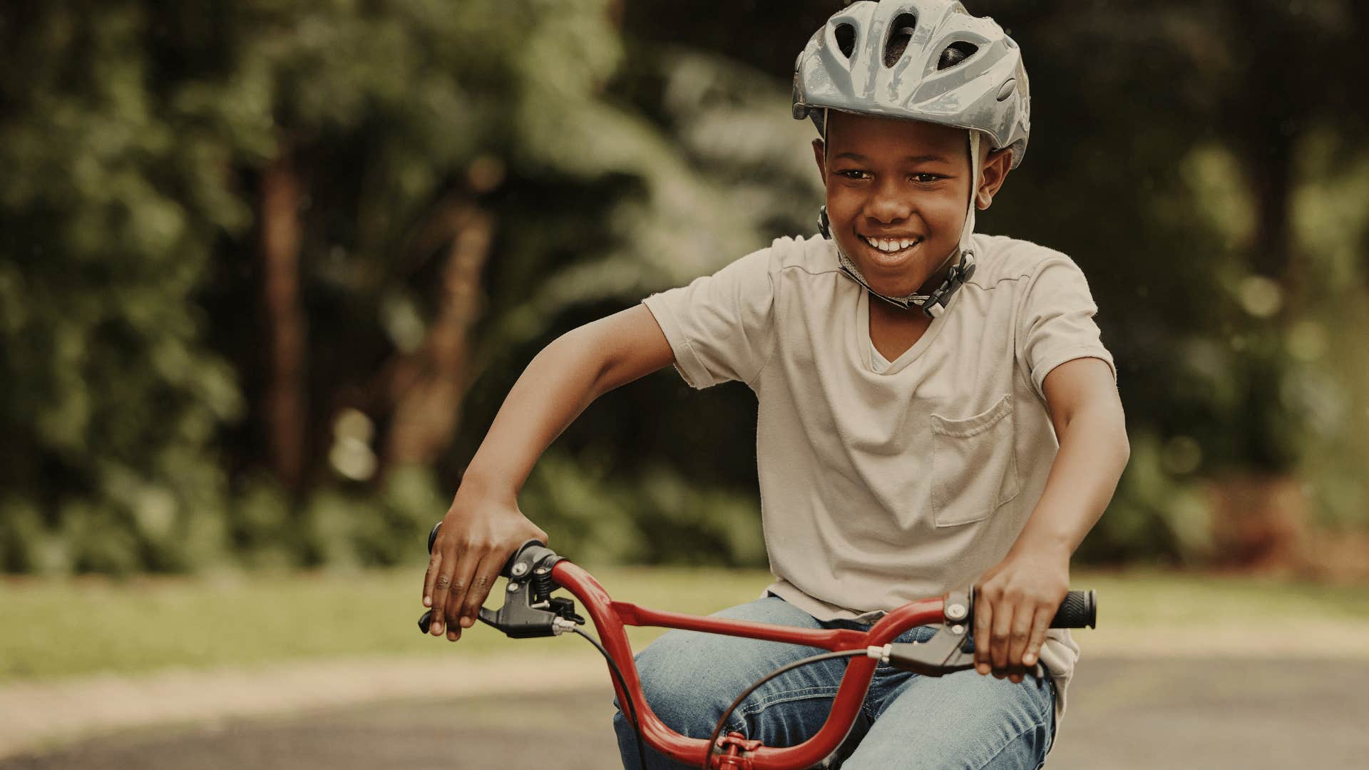 little boy on a bike coming home before the streetlights come on