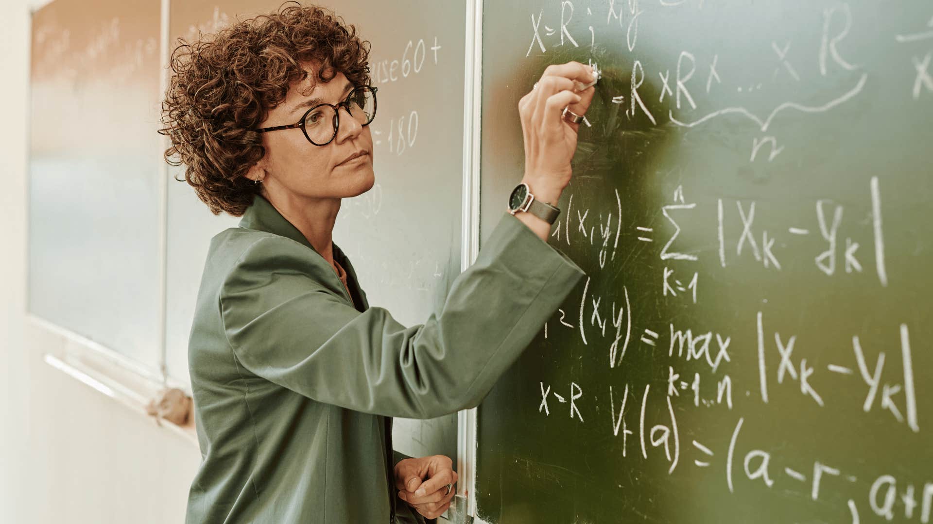 math teacher writing on the chalkboard being an authority figure