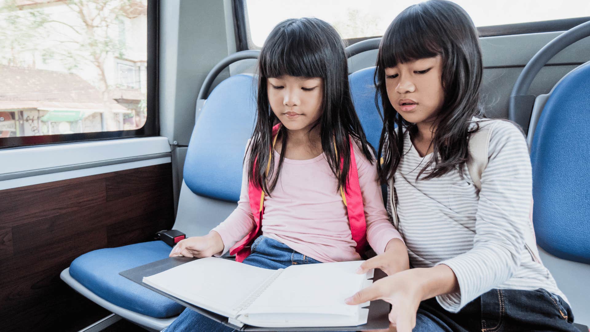 little girls sitting together trying to represent their families well