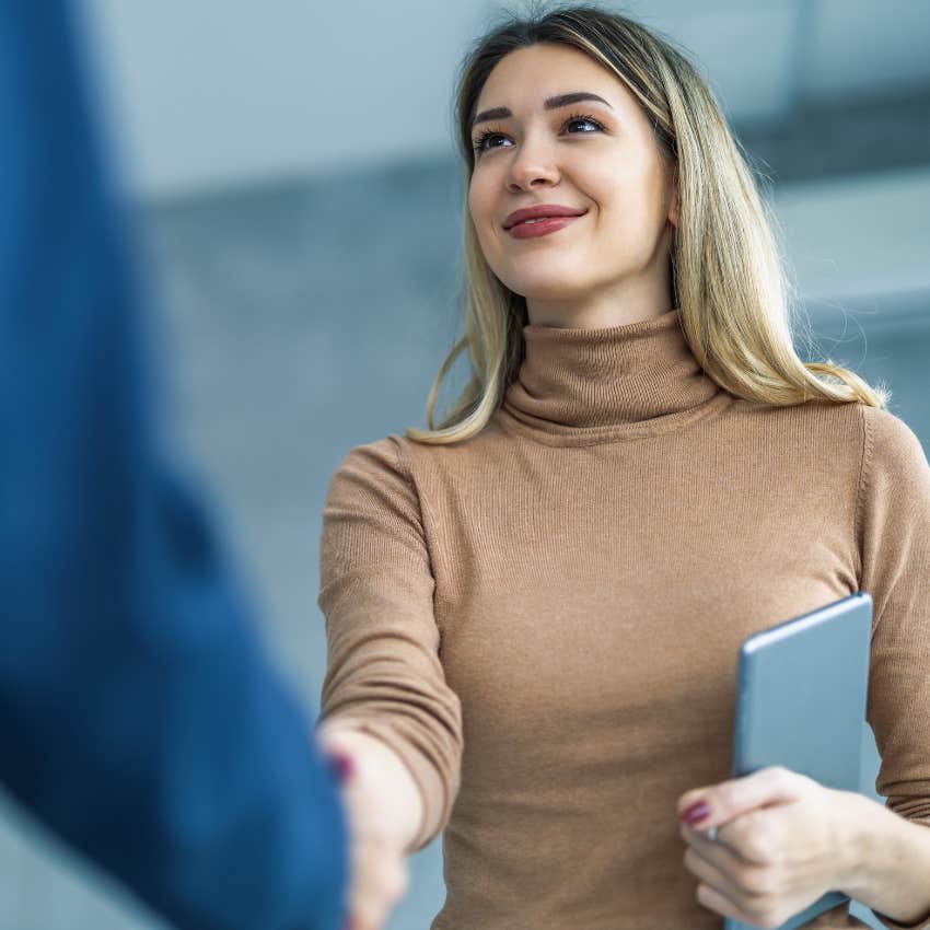 Woman standing up to greet people at work. 