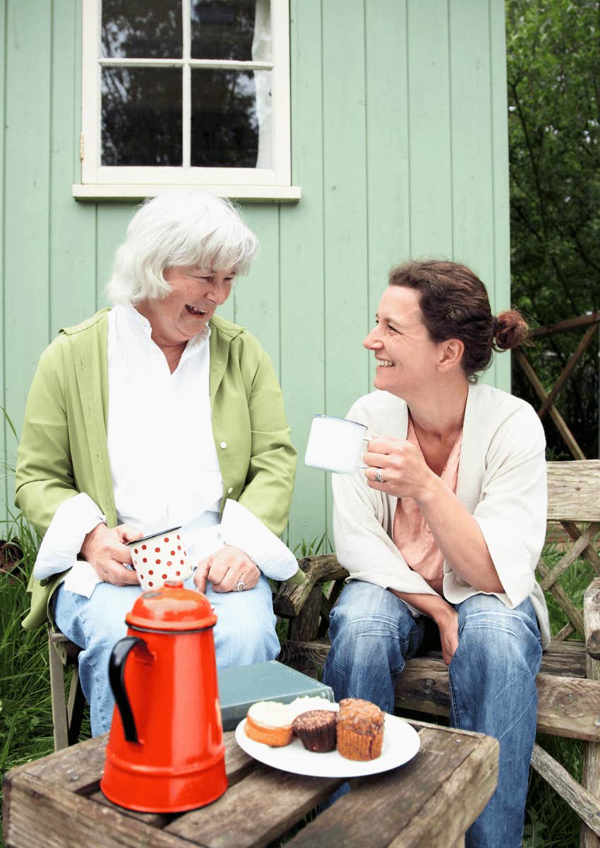 older mom and adult daughter talking outdoors