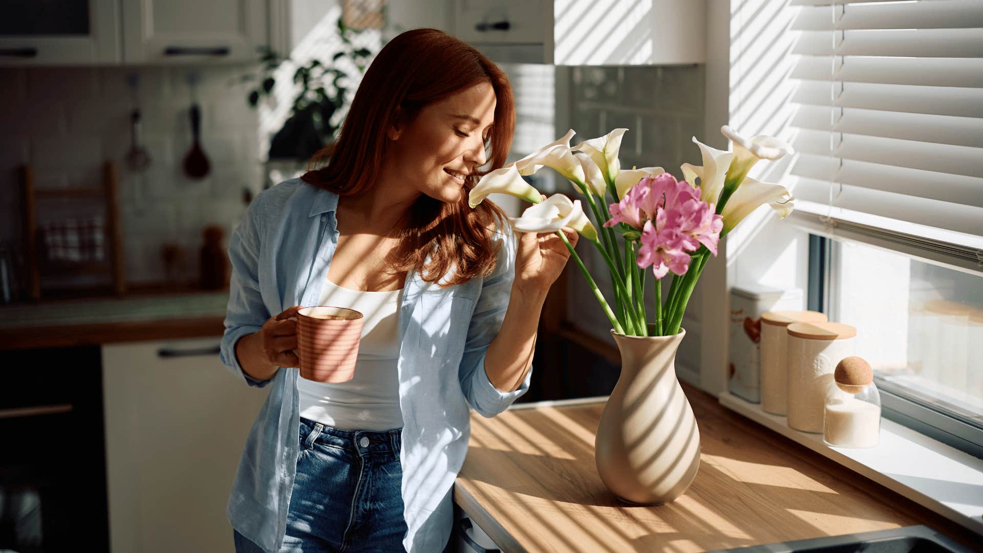 woman smelling flowers as she decorates and organizes her home