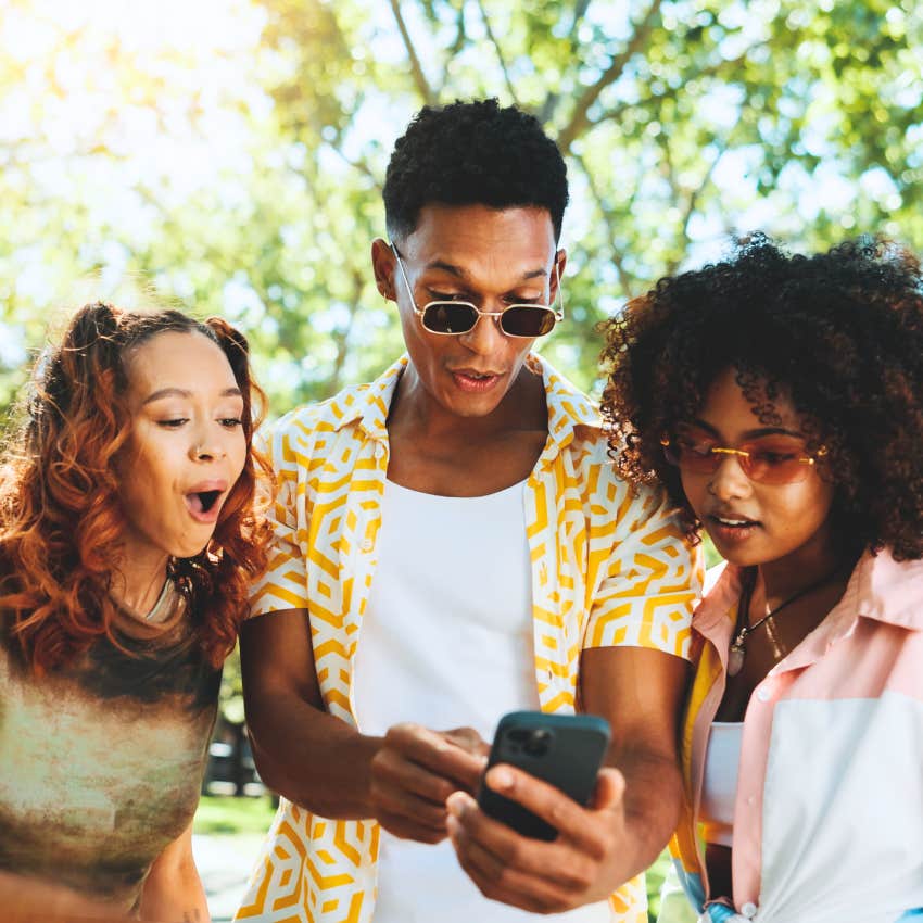 Man saying he's shook to his friends while looking at a phone