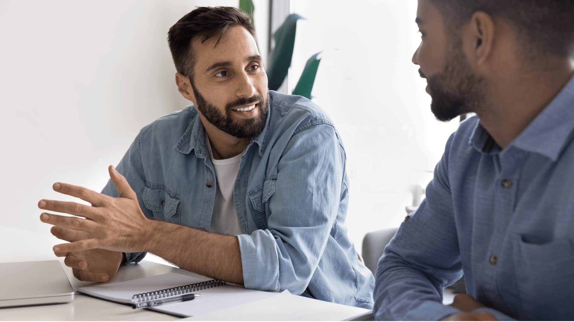 man in light blue jacket telling coworker that's a good idea