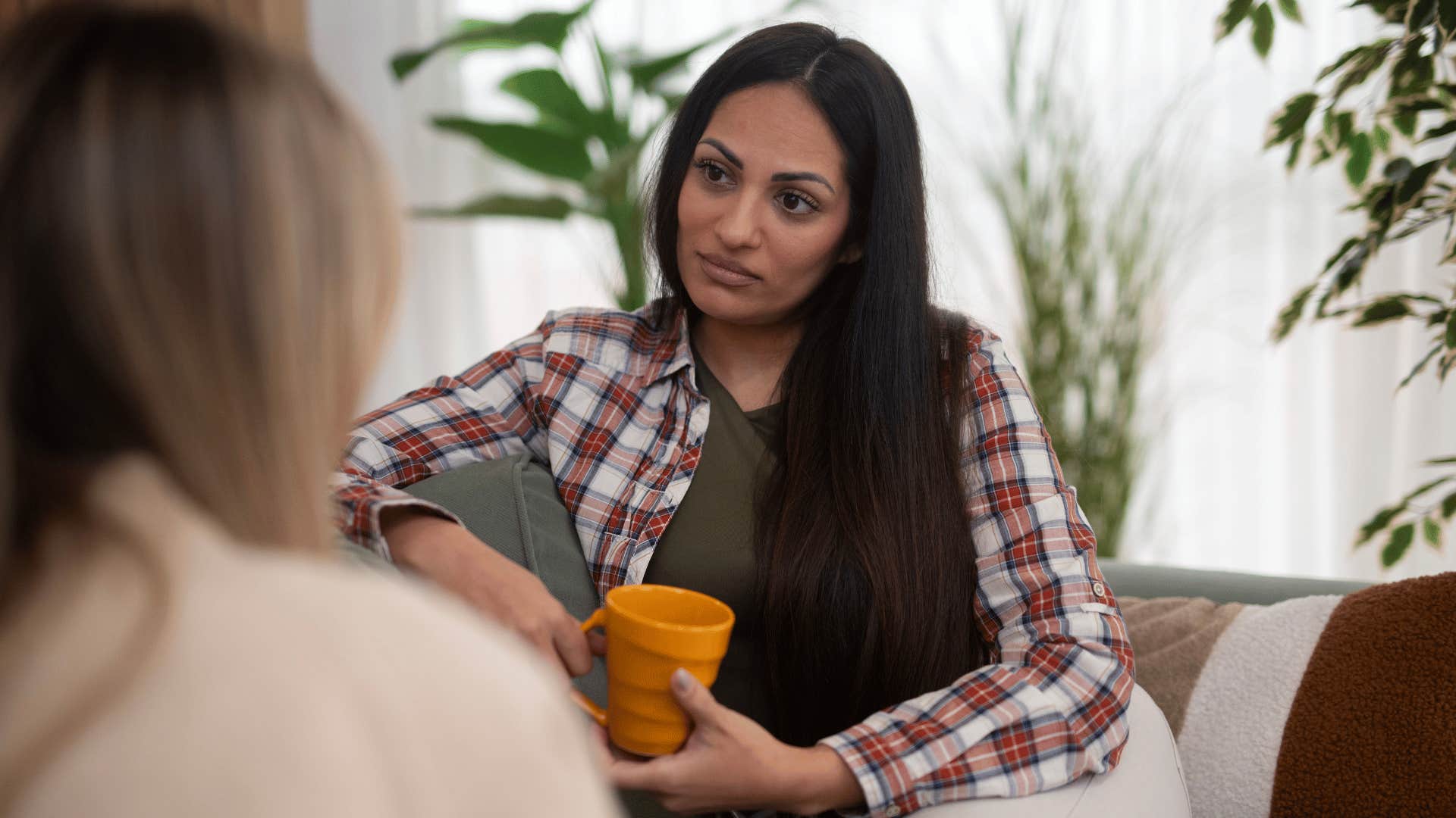 woman in brown shirt listening intensely as she thinks there might be more to the story