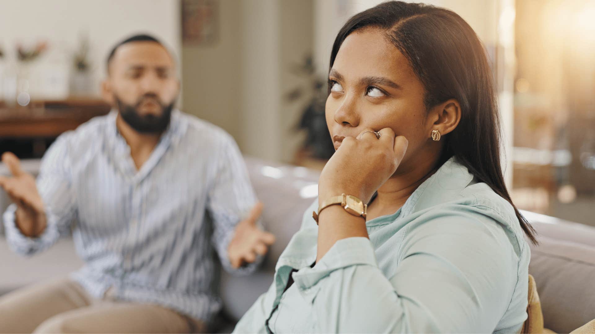 woman rolling her eyes while man tries talking to her