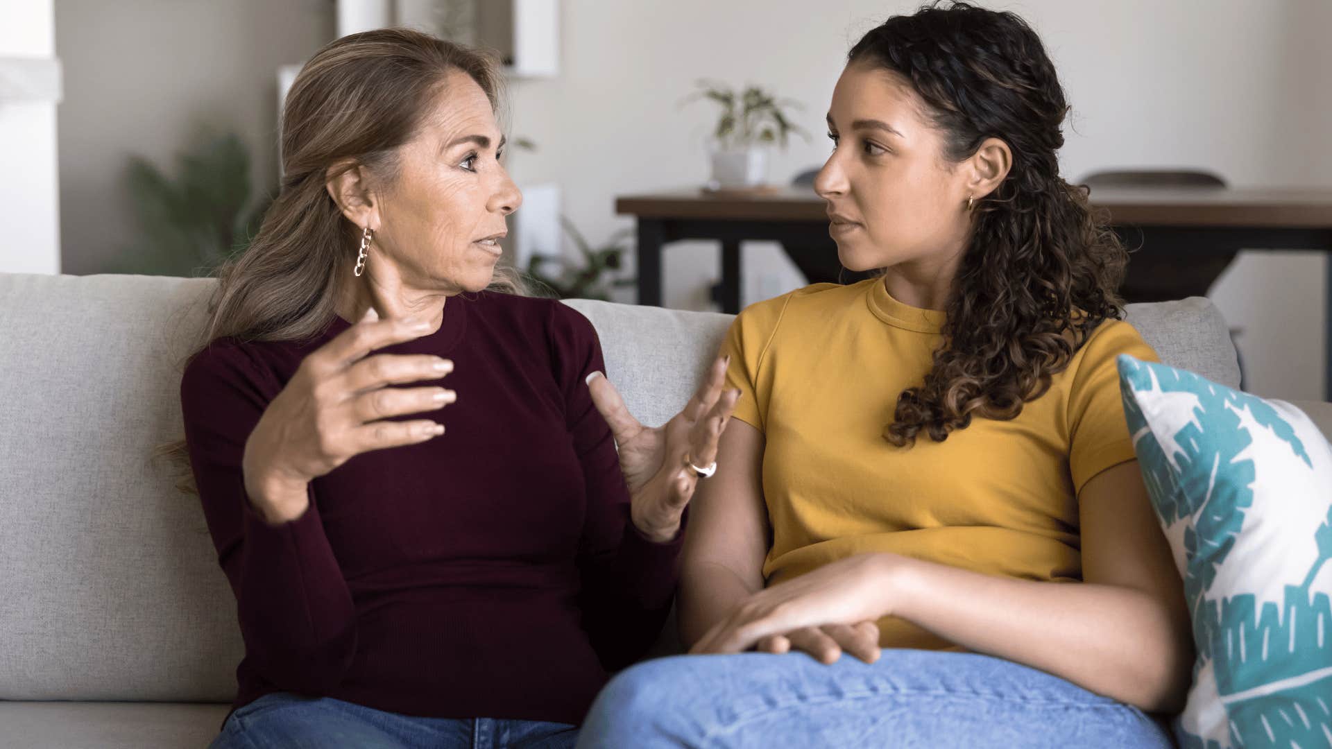 mother and daughter on couch talking as mother in red shirt says this is a good learning lesson