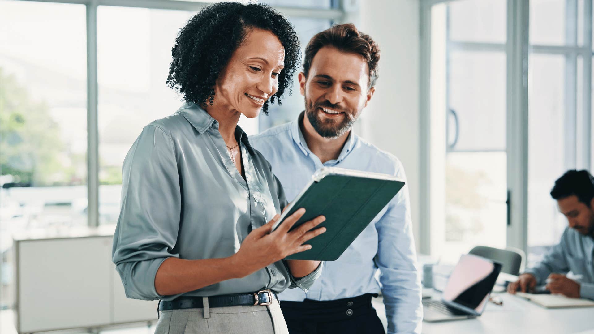 woman coworker looking over documents with man as she says this is just a hiccup and smiles