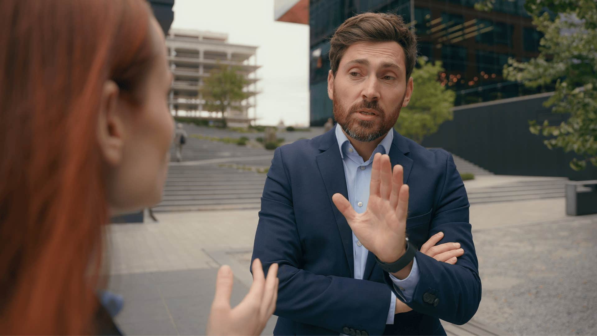 man in professional suit cutting off coworker as he says nobody can tell me what to do