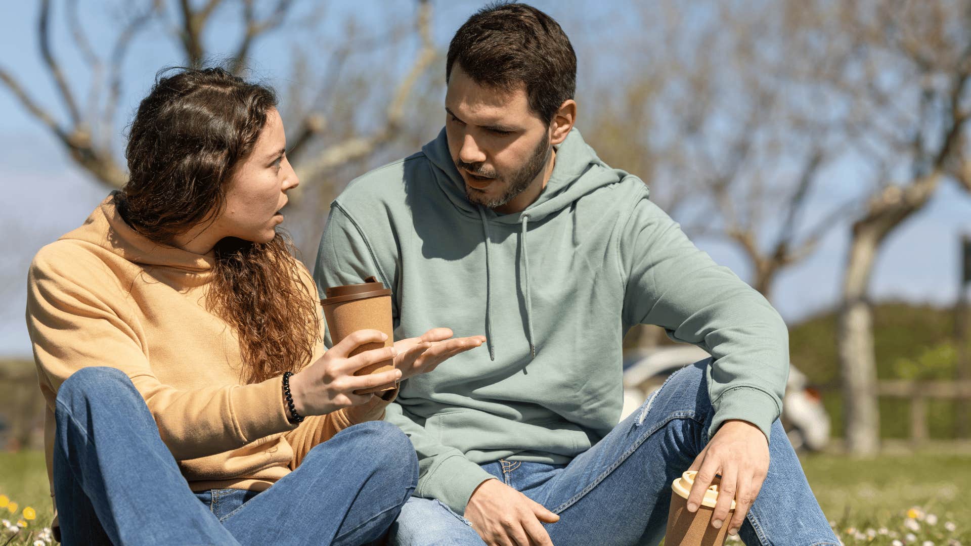 woman scolding man as man in green hoodie says i didn't think to ask