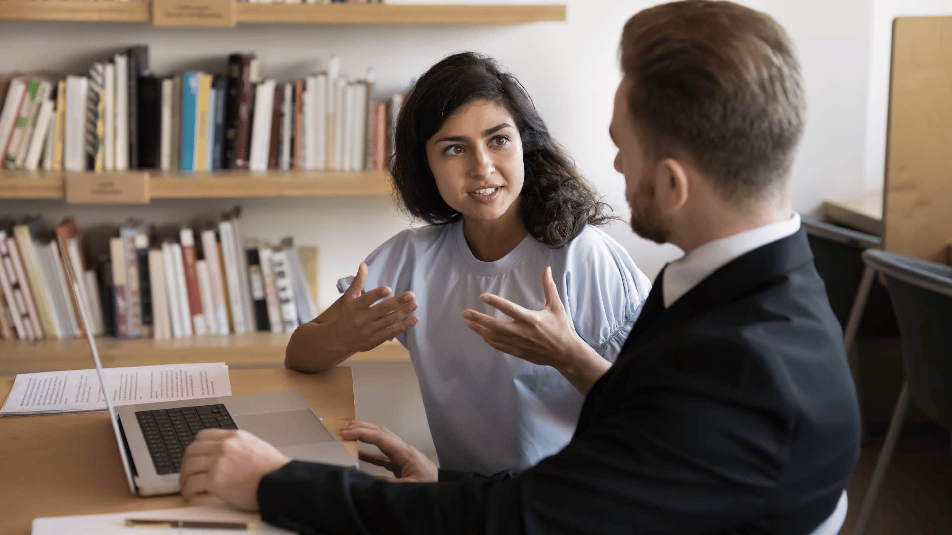woman in blue shirt telling coworker i just went with my first idea