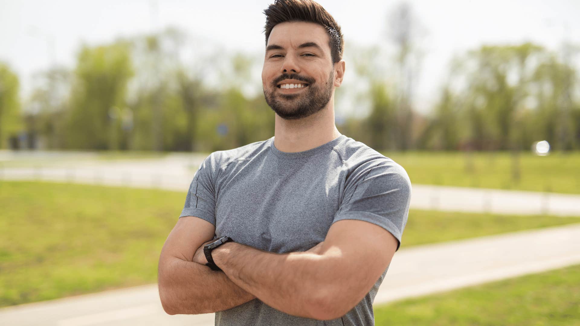 man in gray shirt crossing arms smiling as he thinks all we can do is our best