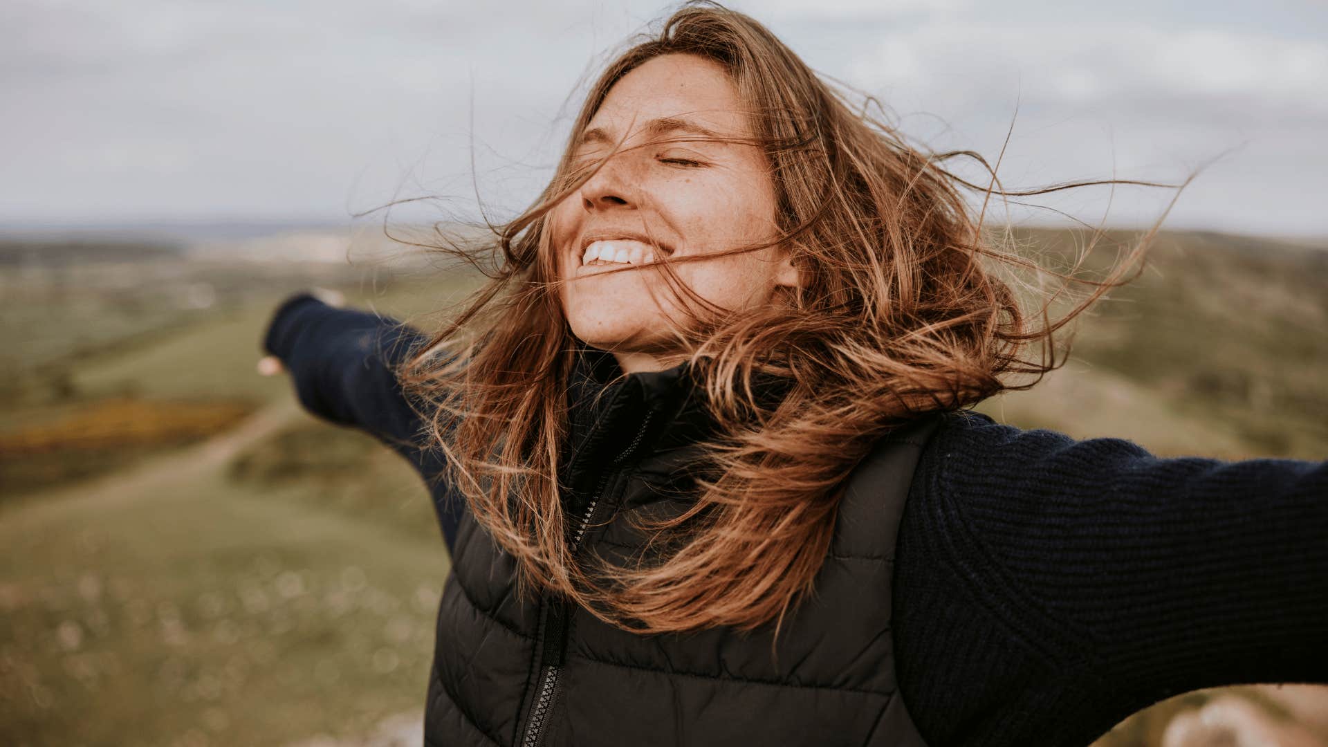 woman in black jacket smiling brightly as she doesn't hold grudges