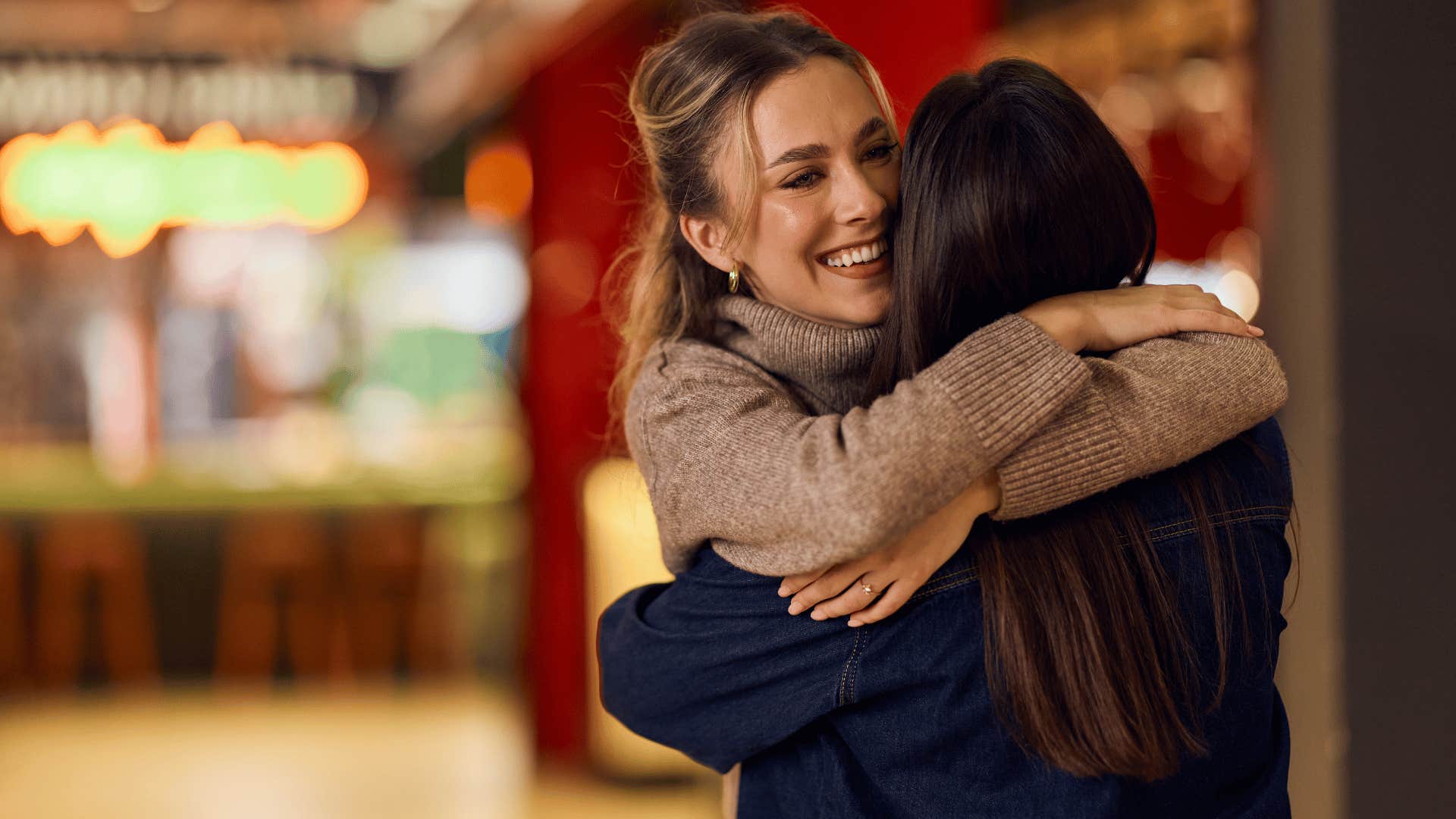 woman in brown sweater hugging woman as she says it's okay we'll get through this