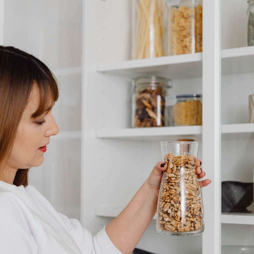 woman organizing glass jars and food containers she saved