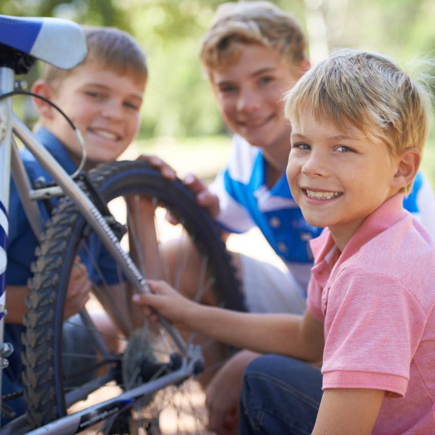 group of young boys taking apart and fixing bike together