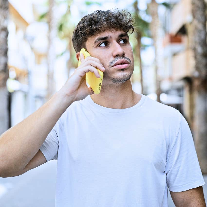 Gen Z man taking an unexpected phone call at home.