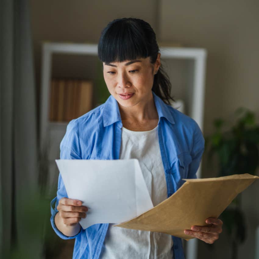 gen x woman looking at stamps on a letter