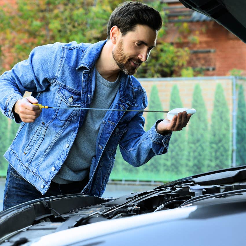 middle aged man fixing things himself with his car in the driveway