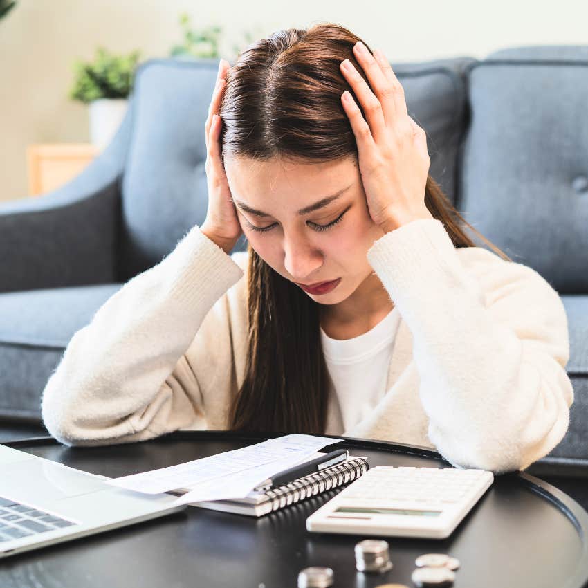 Young woman worrying about student loan debt at home