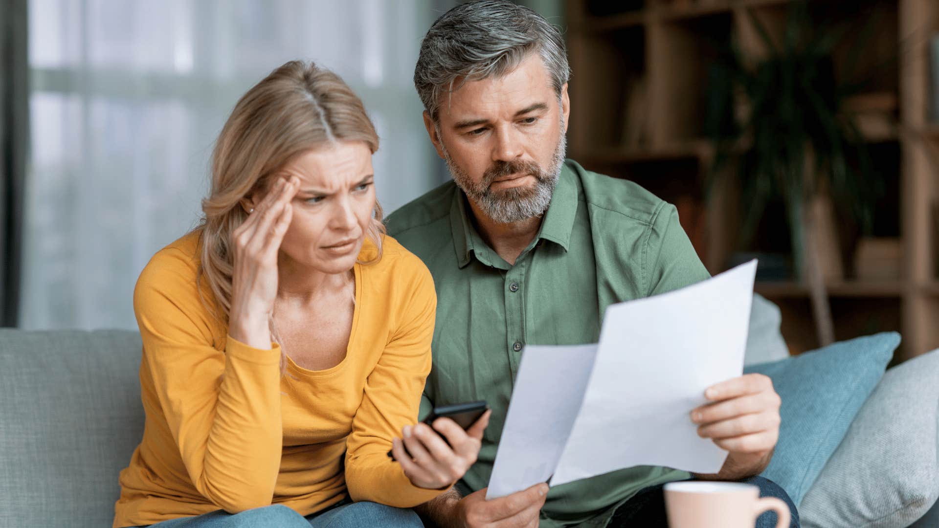 middle aged couple worrying about paying their debt