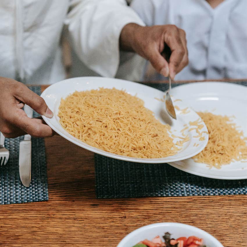 Person preparing a simple homemade rice dish using leftover vegetables and pantry staples