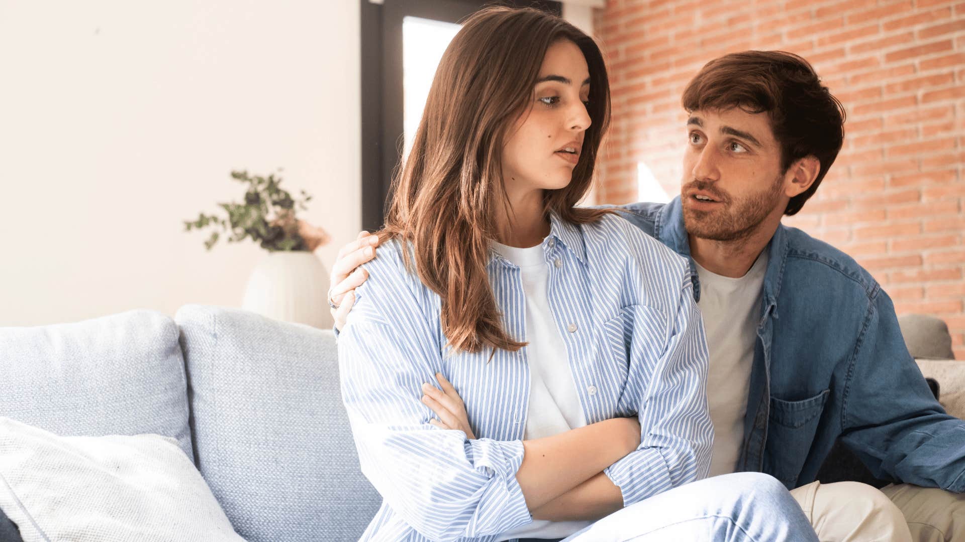 woman crossing arms at partner telling him i don't really care