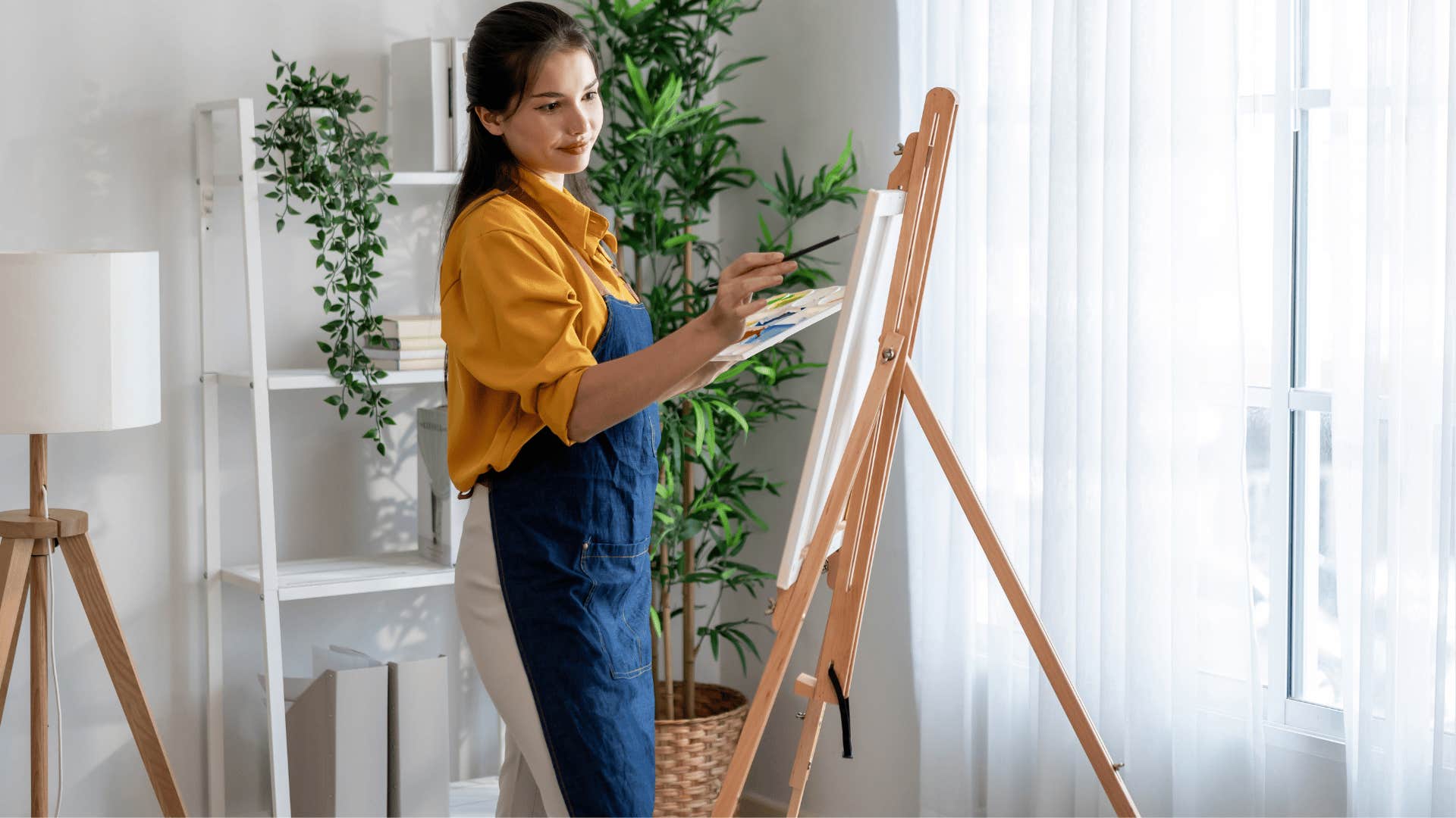 woman in orange shirt painting and drawing while standing