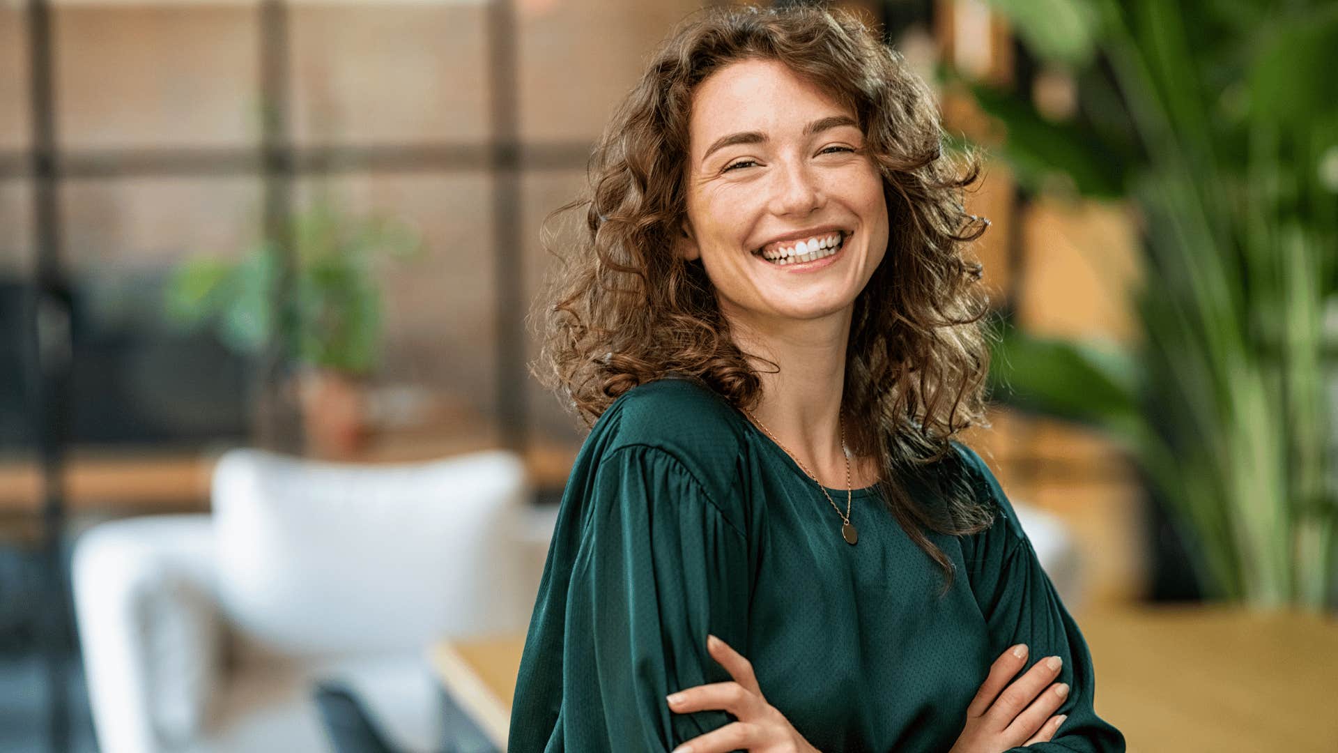 woman in green shirt smiling brightly as she says i don't care what anyone thinks