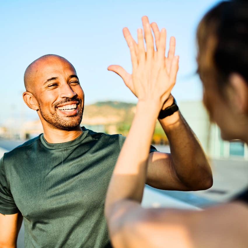 Man who volunteers easily high-fiving his friend.