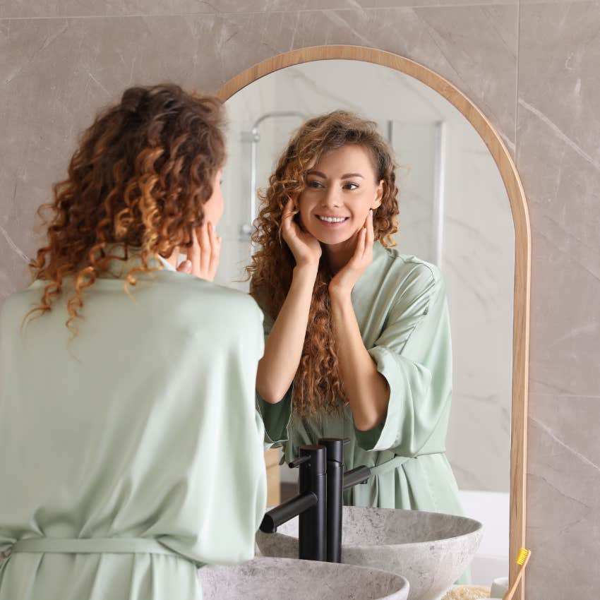 woman who has her life together looking in the mirror by the front door