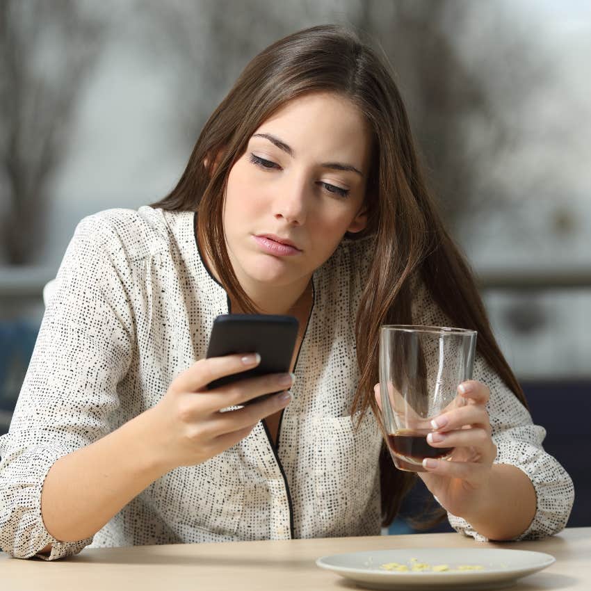 immature woman checking her phone to cancel plans