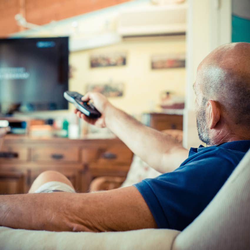 mentally and emotionally lazy man watching tv holding remote